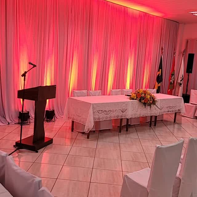 Cerimônia com iluminação rosa, mesa de honra e púlpito montados pela PS SOM & LUZ