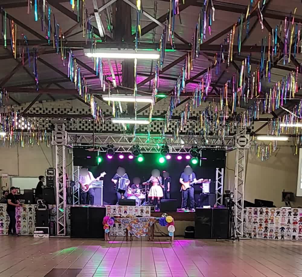 Banda completa se apresentando com iluminação verde no palco