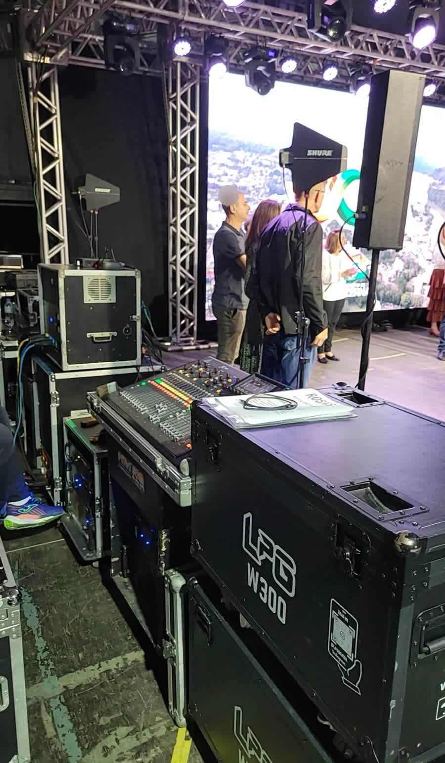 Mesa de som e telão de LED nos bastidores de evento corporativo