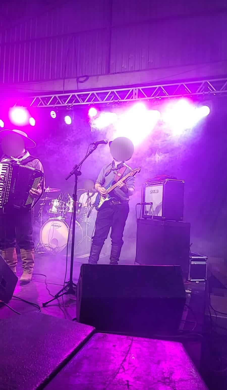 Show ao vivo com iluminação roxa e estrutura de truss